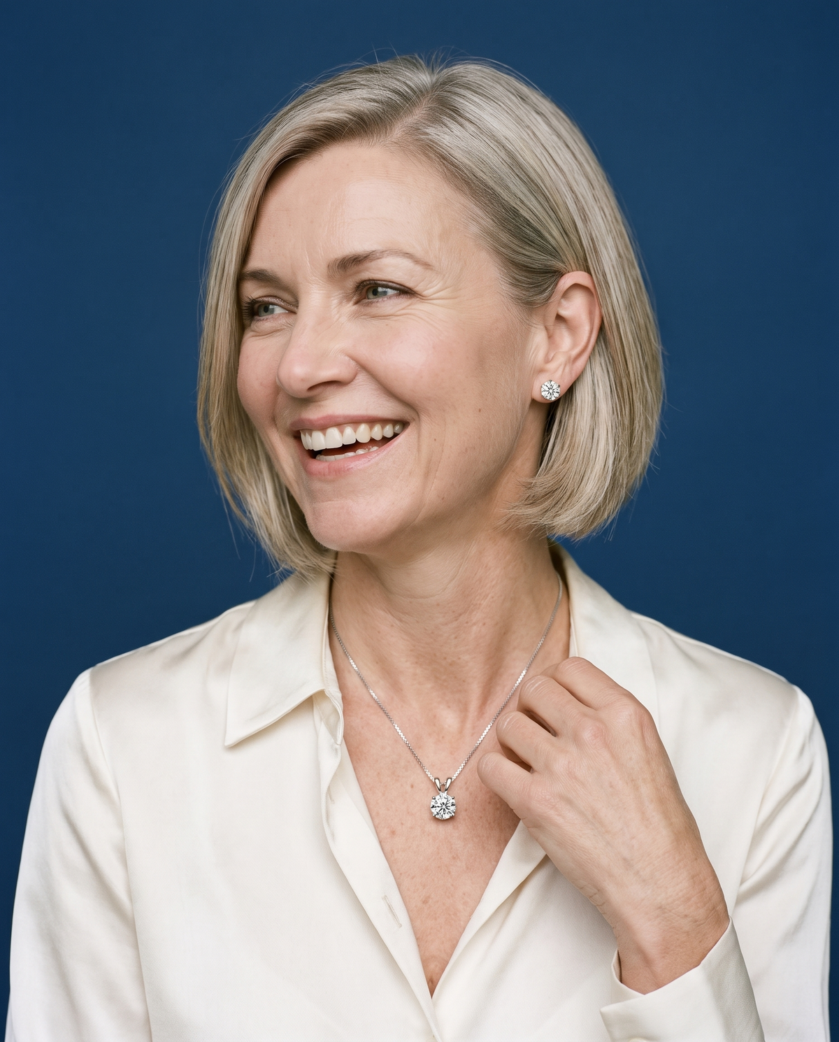 Woman laughing against a royal-blue backdrop, wearing moissanite stud earrings