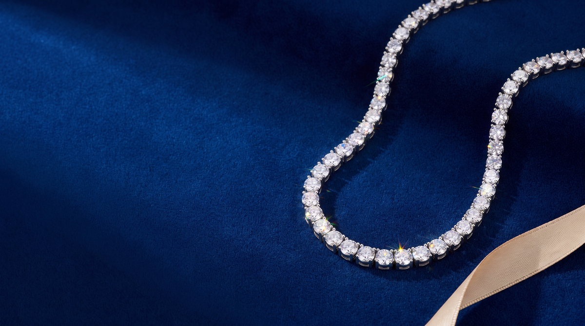 Moissanite tennis necklace resting on royal-blue velvet